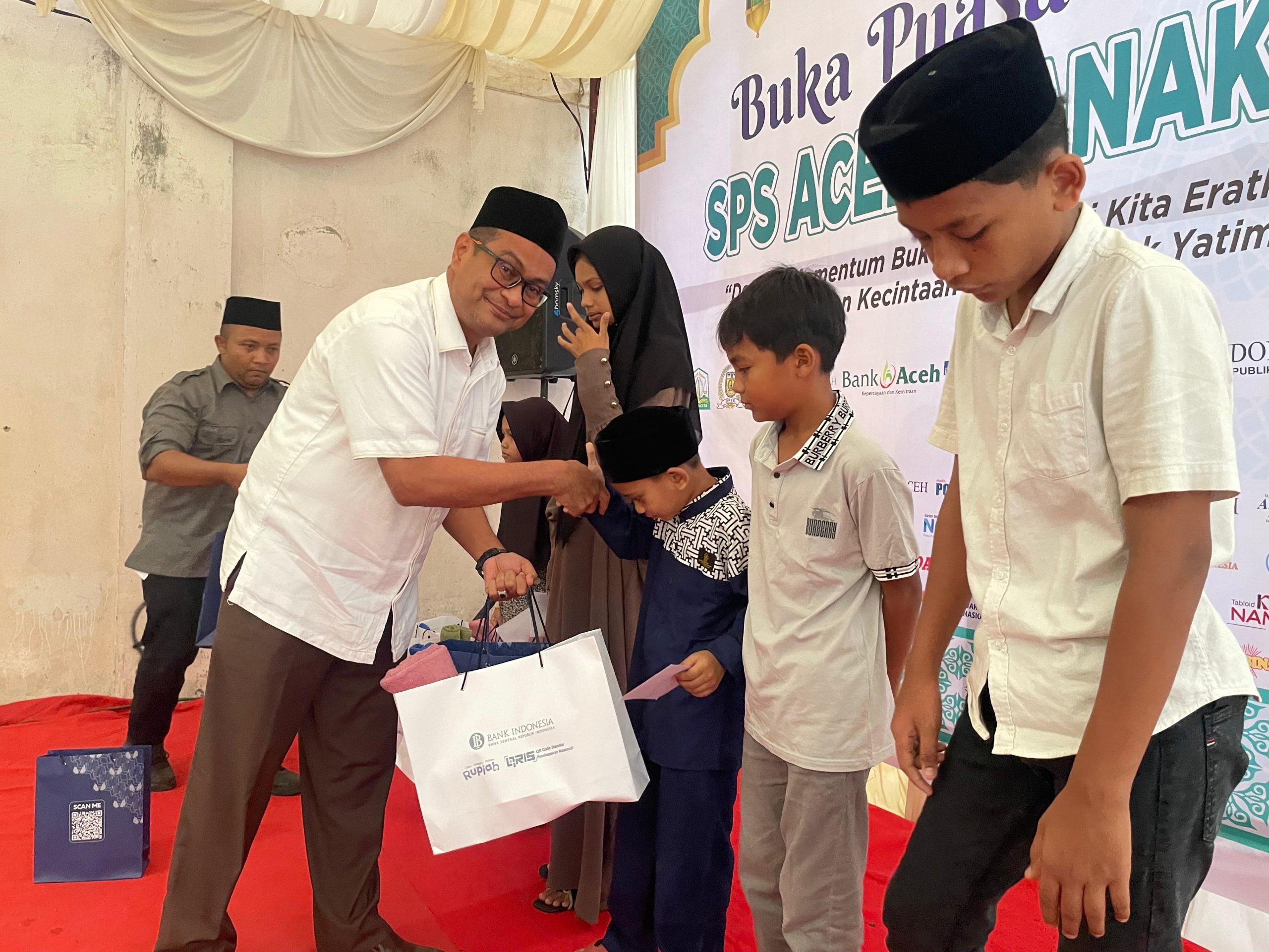 Plt Kadis Kominfo Aceh Besar Khairul Huda SKom MM, menyerahkan santunan kepada anak yatim dalam acara yang digelar SPS Aceh, di Gampong Doy, Kecamatan Ulee Kareng, Kota Banda Aceh, Kamis (20/3/2025) sore.
FOTO/ MC ACEH BESAR.