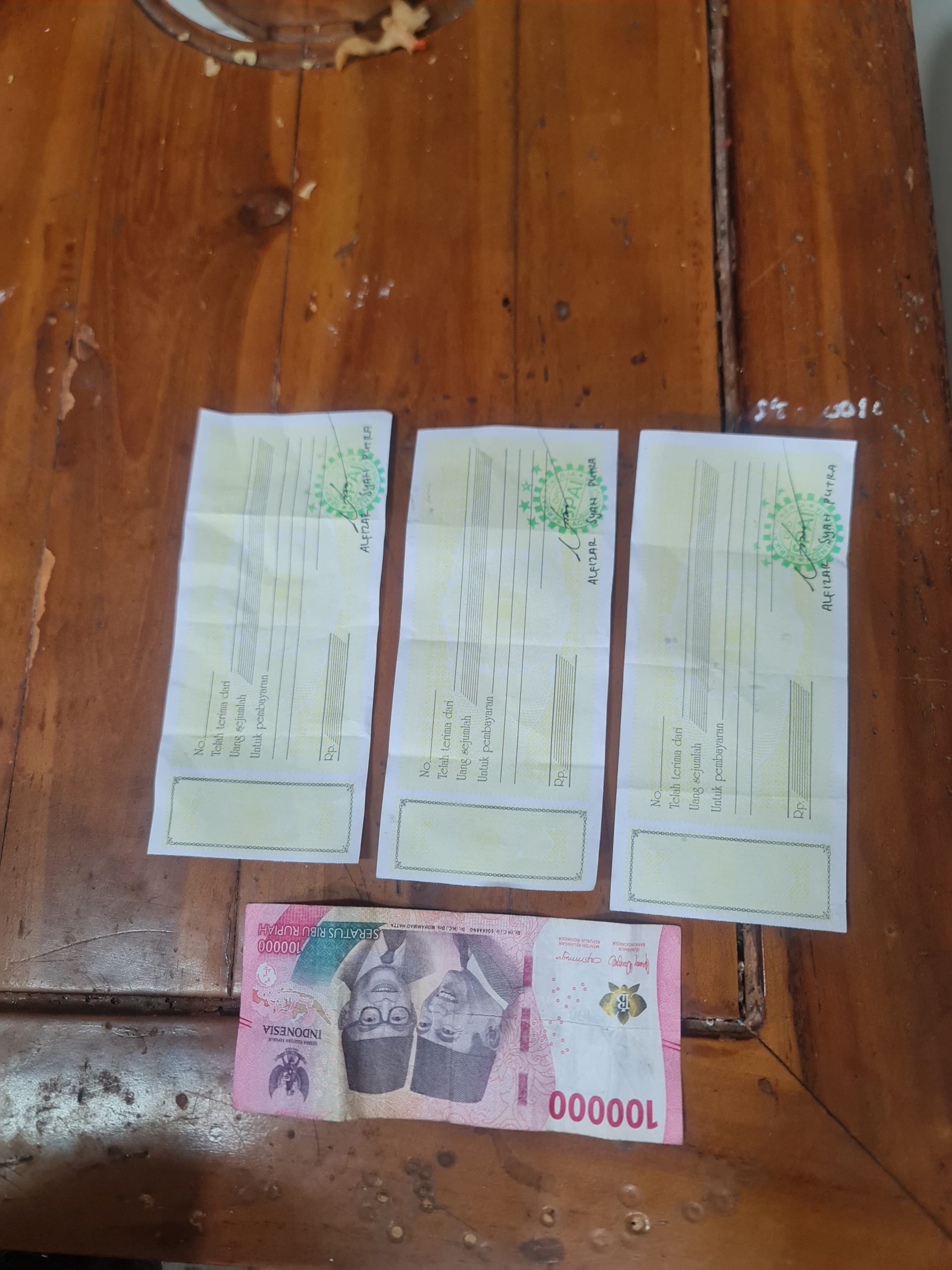 Barang bukti berupa uang pecahan Rp. 100.000 dan tiga lembar kwitansi yang disita Polres dari tangan pelaku, Sabtu, (17/5/2025).(poto/mediaaceh.co.id/istimewa).