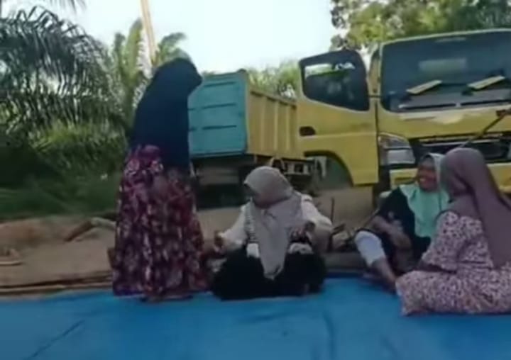 Emak-Emak Menggamat melakukan aksi duduk di badan jalan sebagai protes kepada perusahaan tambang.(Foto/mediaaceh.co.id/istimewa).