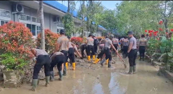 Puluhan personil Satuan Brimob Polda Banten dan Personil Polsek Tanah Jambo Aye sedang membersihkan lumpur dihalaman SMA Negeri 1 Tanah Jambo Aye, Sabtu, (3/1).