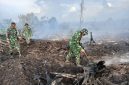 Saat anggota TNI memadamkan api hutan terbakar.