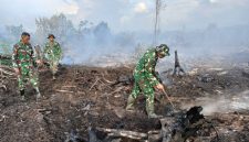 Saat anggota TNI memadamkan api hutan terbakar.