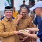 Bupati Aceh Utara Ayah Wa saat diserahkan potongan beras kenta oleh pihak Yayasan Buddha Tzu Chi pada acara peresmian Huntap di Gampong Alue Papeun, Senin, (28/9).